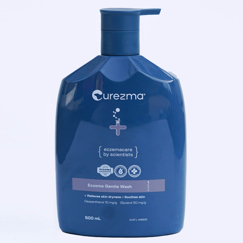 Blue bottle of Curezma Eczema Gentle Wash on a light purple background