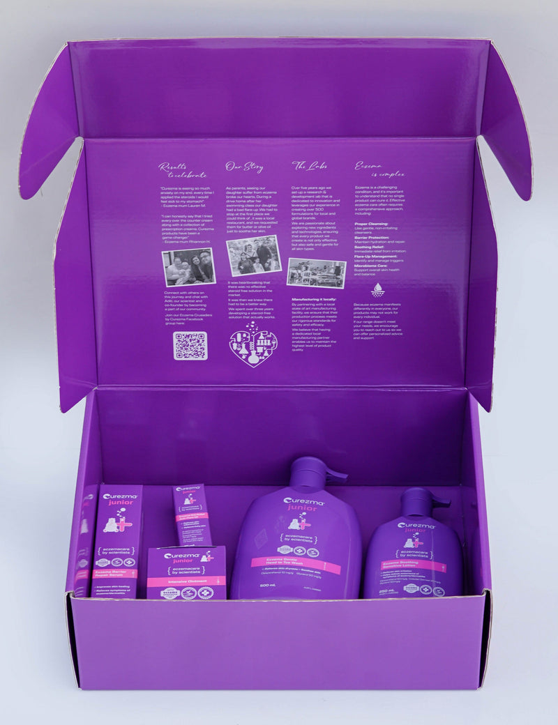Purple product set with bottles and boxes inside an open purple box on a light gray background