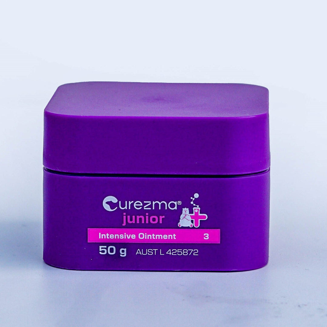 Purple jar of Curezma junior Intensive Ointment on a light purple background